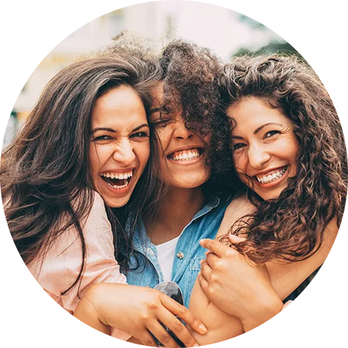 Three women hugging and laughing together