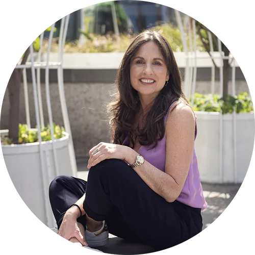 Sarah Gale sitting in a garden in a lilac top