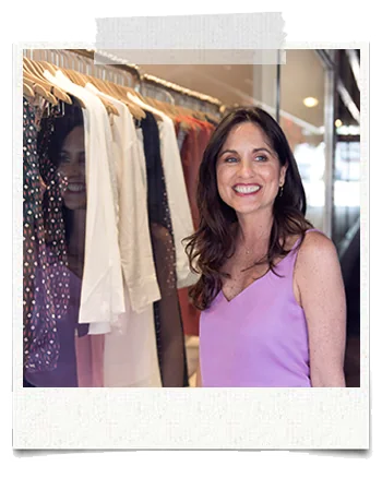 Taped polaroid of Sarah Gale smiling beside a clothing rack