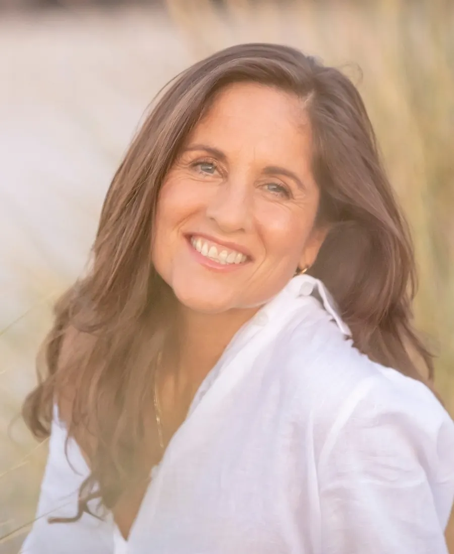 Sarah Gale smiling in a white linen shirt in soft golden light
